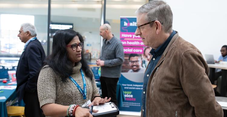 woman talks to man at healthwatch event