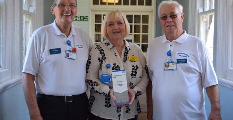 Photo of Aintree Hospital volunteers Eric, Gail and Ged holding their award