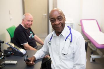 Image of a male doctor speaking to a male patient. 