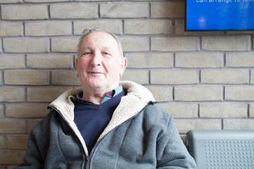 man sat in front of a brick wall