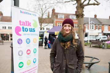 Young woman standing next to a talk to us sign