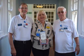 Photo of Aintree Hospital volunteers Eric, Gail and Ged holding their award