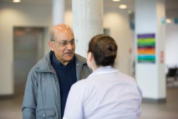 Man talking to health professional in waiting room