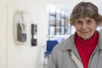 older person standing in hospital corridor