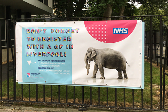 Image of a banner on the University of Liverpool campus reminding students to register with a GP