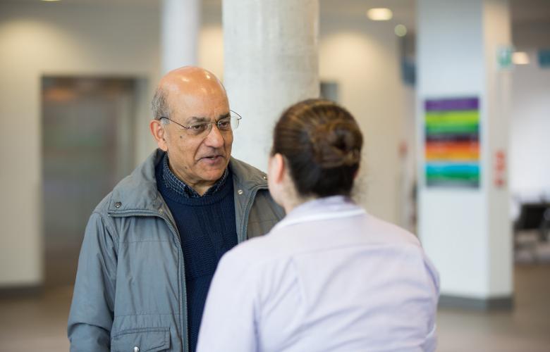 Man talking to health professional in waiting room